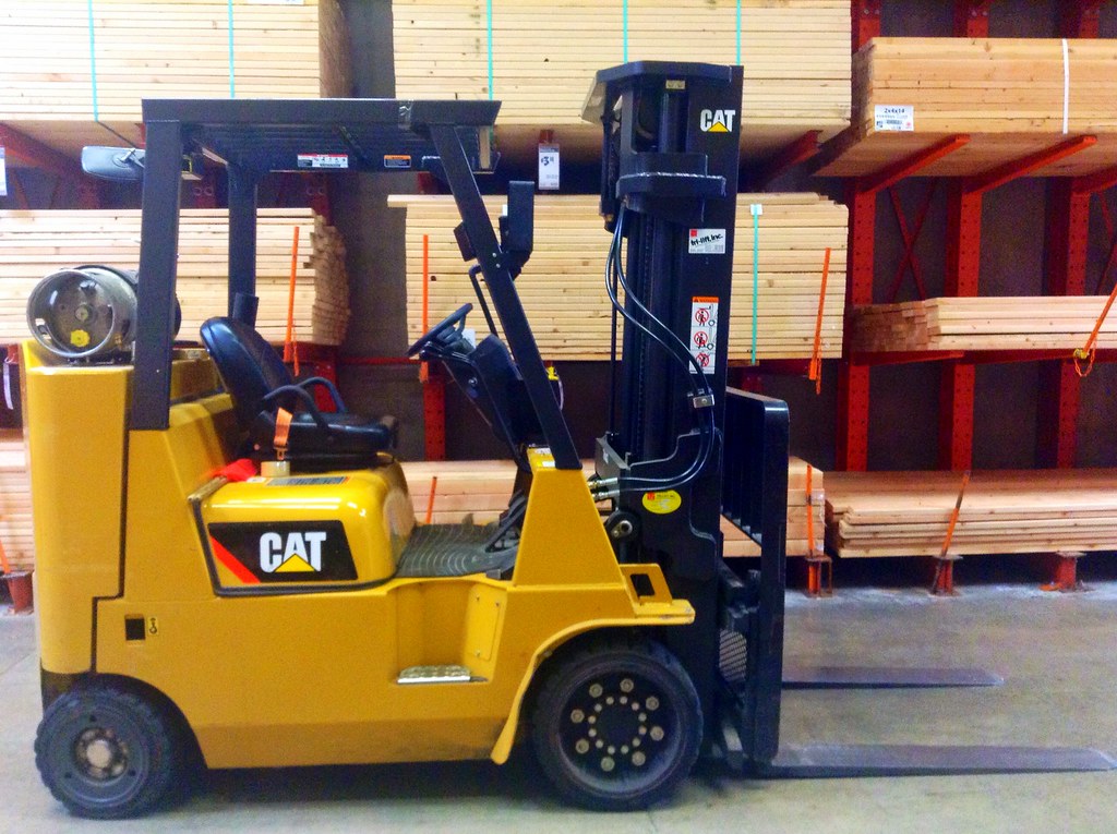 Forklift lifting stacked material in a warehouse